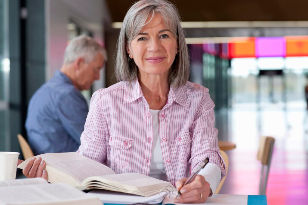 Smiling mature student studying textbook